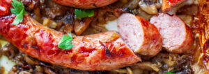 Pieczona biała kiełbasa z cebulą i pieczarkami