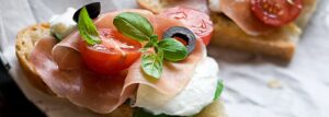 Bruschetta z mozzarellą, szynką parmeńską i pomidorkami koktajlowymi