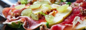 Carpaccio z gruszki z szynką parmeńską, winogronami i tartym parmezanem