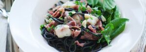 Czarny makaron z żabnicą, szynką parmeńską i szczawiem