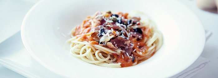 Makaron z sosem pomidorowym, szynką parmeńską i czarnymi oliwkami