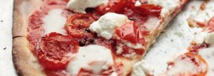 Pizza cienka i chrupiąca z pomidorami i mozzarellą
