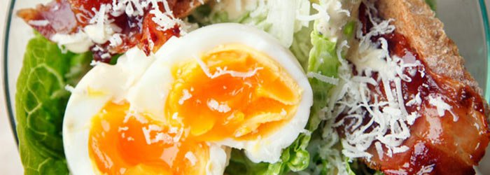 Caesar salad with egg and crispy bacon