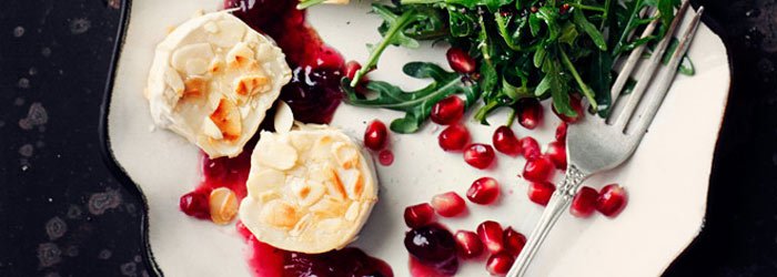 Salad with arugula, warm goat cheese in almonds and pomegranate