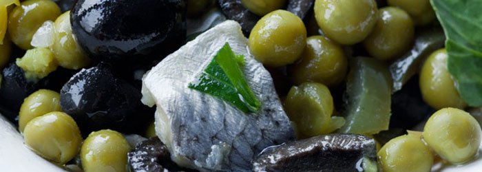 Salad with herrings, green peas and black olives
